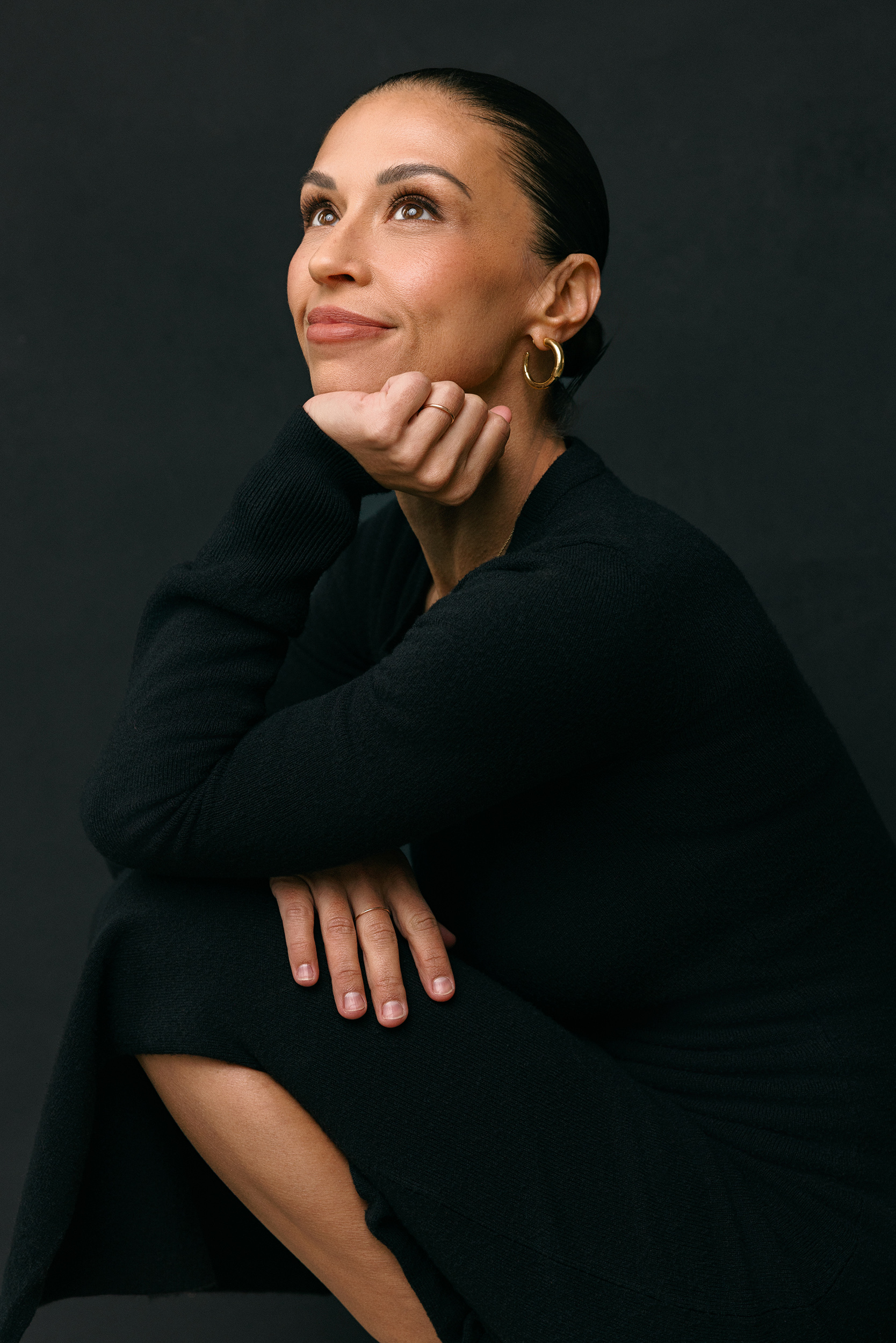 editorial headshot of female realtor wearing all black on a black backdrop